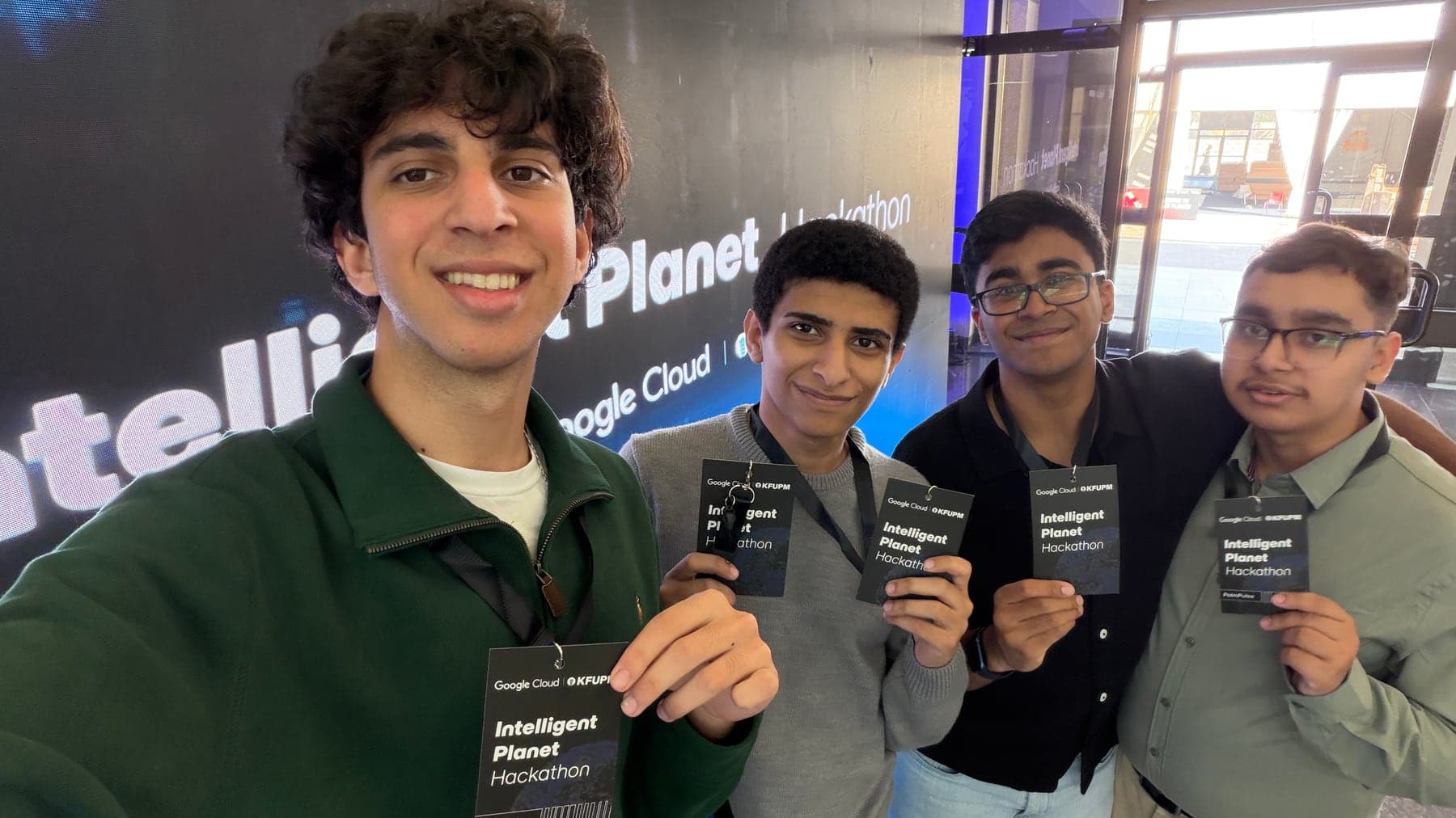 The PalmPulse team holding Intelligent Planet Hackathon badges